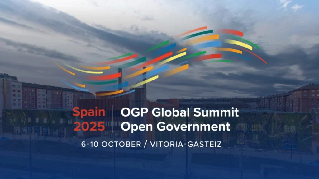 Imagen institucional de la cumbre global de OGP, con el logo de la cumbre que dice "Spain 2025, OGP Global Summit Open Government, 6-10 October / Vitoria-Gasteiz" sobre una imagen panorámica de la ciudad de Vitoria-Gasteiz.